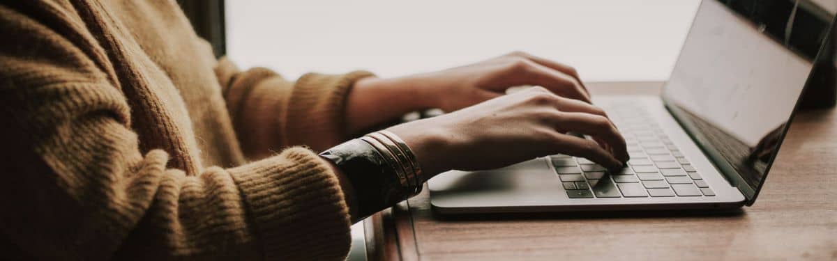 Hände tippen auf einer Laptop-Tastatur