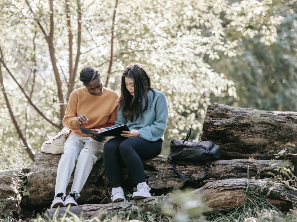 Zwei Menschen sitzen gemeinsam im Freien auf einem Felsen